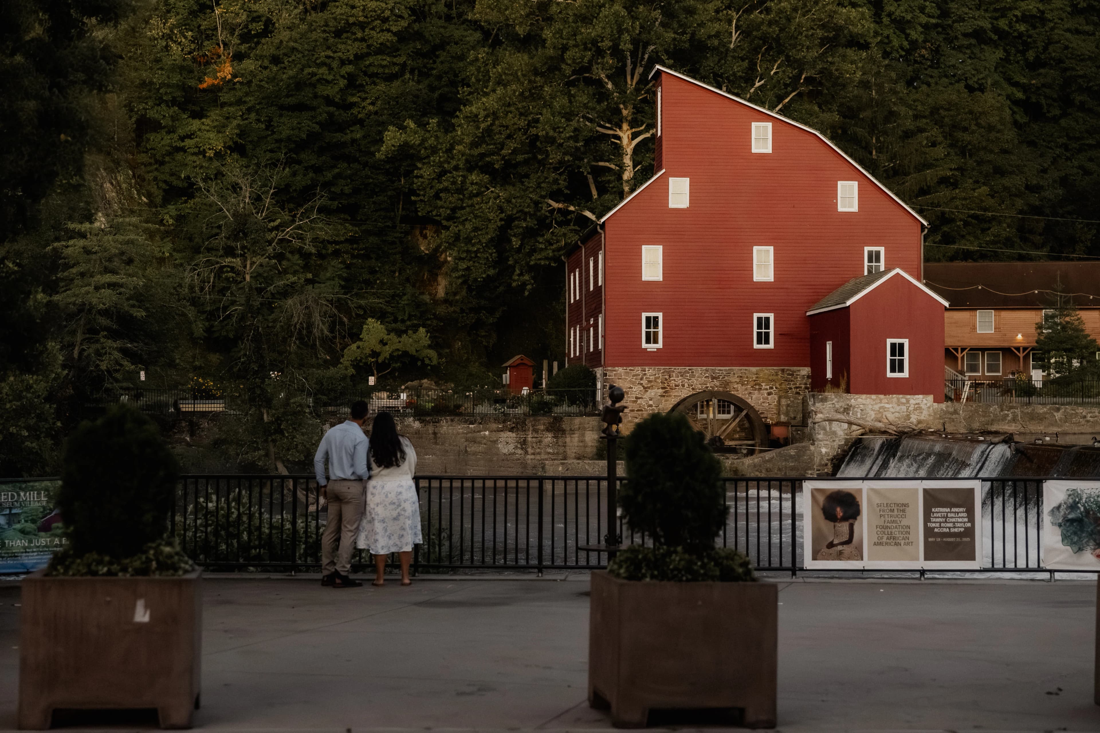 Anthony and Lily looking out at the Red Mill and waterfall