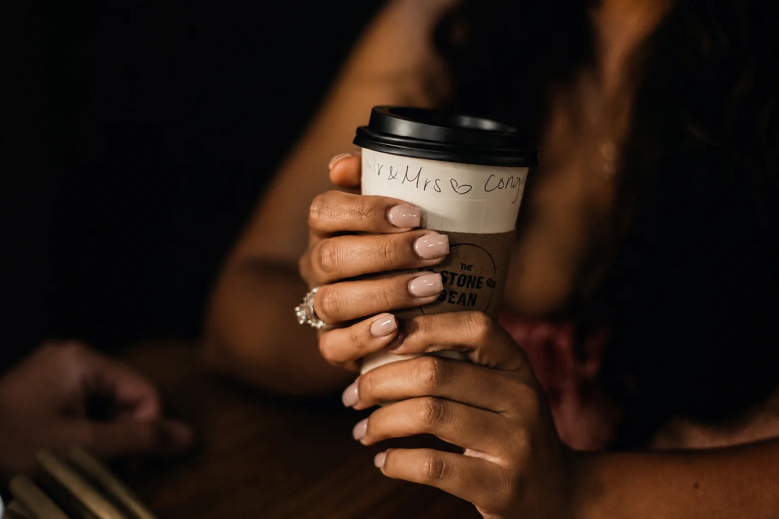 Lily holding a coffee cup that reads Mr and Mrs, congrats